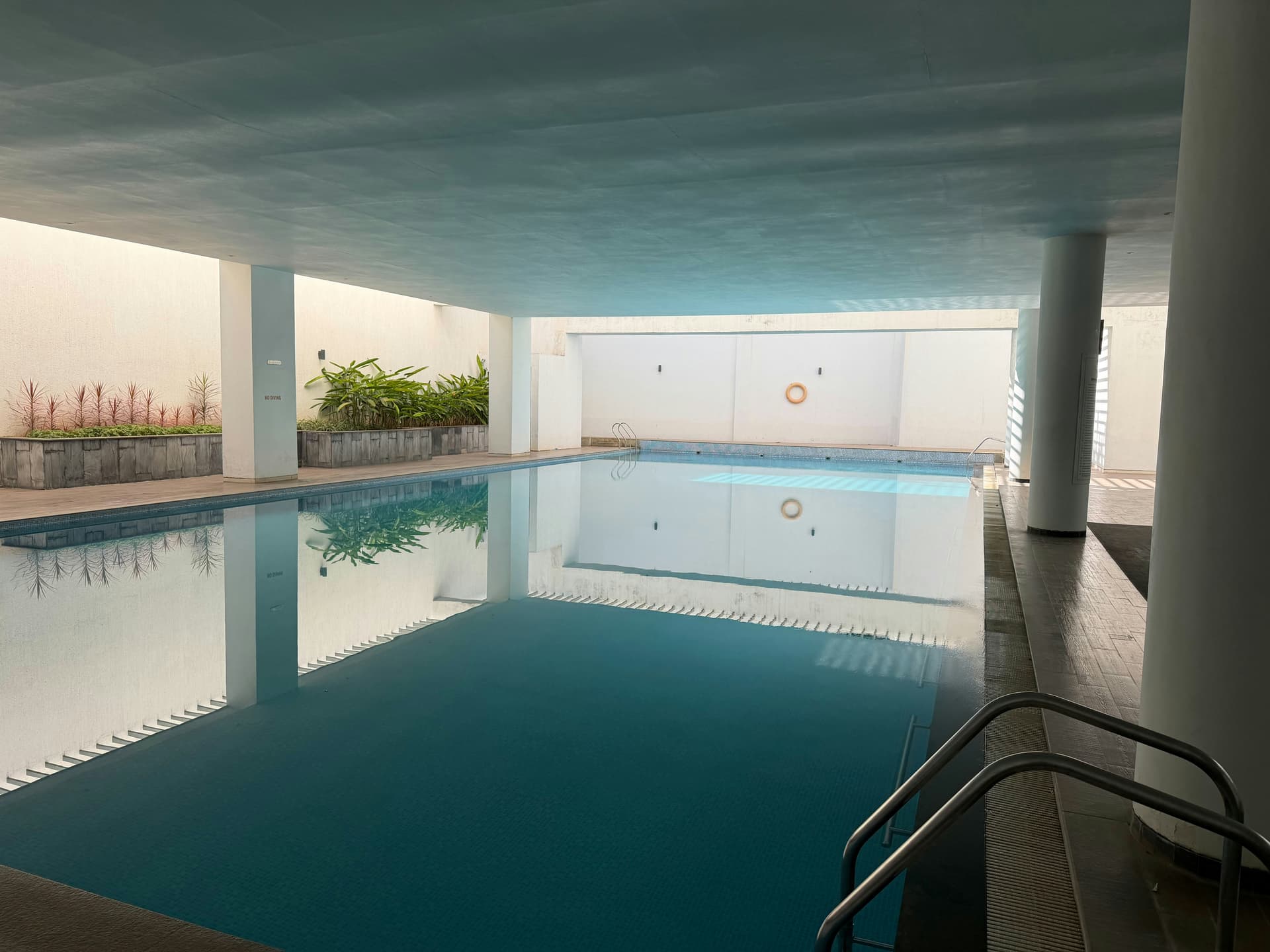 Covered indoor pool looking out to a garden